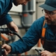 Plumber inspecting cast iron pipe with specialized equipment for pipe lining services.