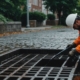 Professional worker cleaning a commercial storm drain with specialized equipment, highlighting the importance of regular maintenance.