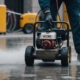 Technician using high-pressure water jet to clean a dirty concrete surface, showcasing effective water jetting services.