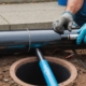 Worker installing drain pipe lining